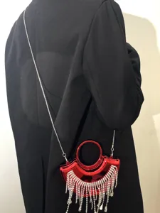 Detailansicht der glänzenden roten Mini-Abendtasche mit funkelnden Strass-Fransen und Kette.