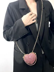 Detaillierte Ansicht der herzförmigen Strass-Umhängetasche mit rosa Kristallen und goldener Kette.