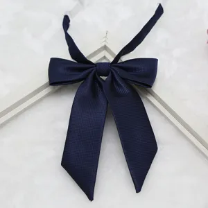 Navy blue fine textured fabric detail of JK uniform bow tie collar accessory closeup shot.