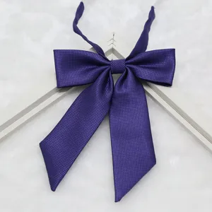 Close-up detail of dark purple JK uniform bow tie, fine texture fabric, elegant pointed ribbon.