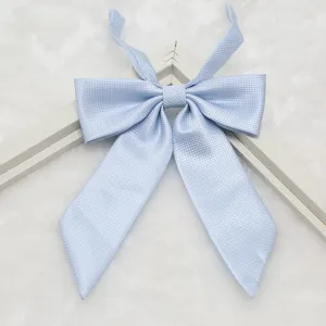 Close-up detail of light blue ribbed JK uniform bow tie, textured fabric and pointed end.