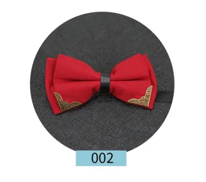 Primo piano dettagliato del papillon rosso con angoli in metallo dorato e cinturino nero.