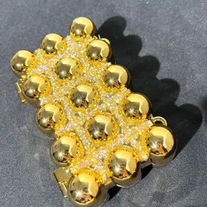 Gold sphere rhinestone evening bag detail, sparkling acrylic design, stylish luxury clutch purse.