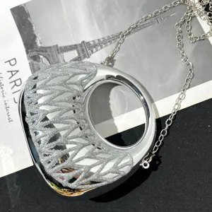 Silberne metallische Mondsichel Handtasche mit Glitzer Overlay und eleganter Kette für Damen.