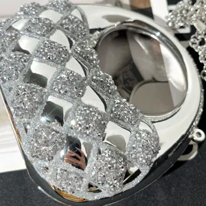 Nahaufnahme einer glamourösen silbernen Acryl Abendtasche mit funkelndem Strass-Netzwerk.