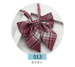 Closeup of a burgundy plaid JK uniform bow tie, showing detailed fabric texture and sharp corners.