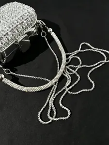Detailaufnahme der silbernen Strass Abendtasche mit elegantem Metallrahmen und Kette.