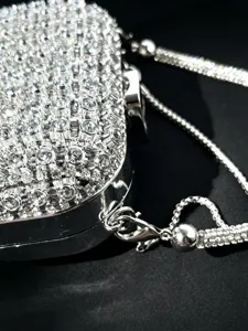 Nahaufnahme einer glitzernden Strass-Abendtasche mit edler metallischer Kette.