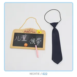 Detail view of children elastic necktie with blackboard prop for kids apparel presentation.