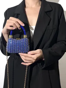 Detailansicht einer luxuriösen blauen Strass-Abendtasche Handtasche mit Goldkette für Damen.