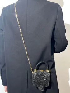 Nahaufnahme einer funkelnden Strass-Abendtasche mit Fransen und edler goldener Kette.