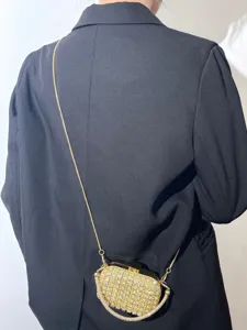 Nahaufnahme der luxuriösen goldenen Strass-Abendtasche mit filigranem Kettengürtel.