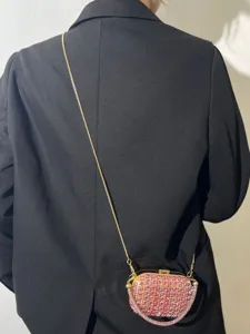 Detailansicht einer glitzernden rosa Strass Mini Umhängetasche mit feiner Goldkette.