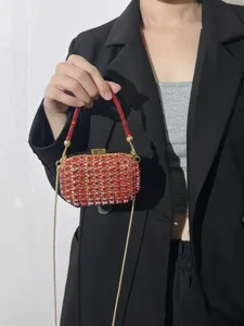 Nahaufnahme der funkelnden roten Strass-Mini-Umhängetasche mit goldener Kette und Verschluss.