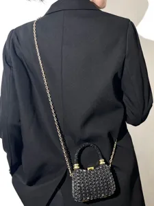 Glitzernde Mini-Abendtasche Detail mit funkelnden Strasssteinen, Goldkette und schwarzem Griff.