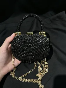 Detailaufnahme einer schwarzen Strass-Abendtasche mit goldener Kette und Griff, eleganter Stil.