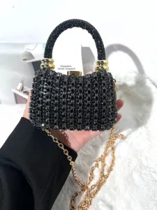 Detailansicht der glitzernden schwarzen Strass-Abendtasche mit Metallgriff und goldener Kette.