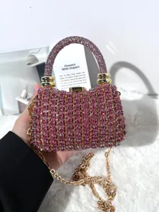 Detailaufnahme einer atemberaubenden rosa Strass-Abendtasche mit eleganter Goldkette.