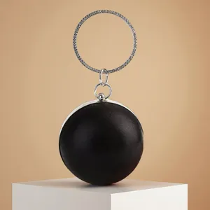 Élégante pochette de soirée ronde noire avec poignée anneau strass scintillante.