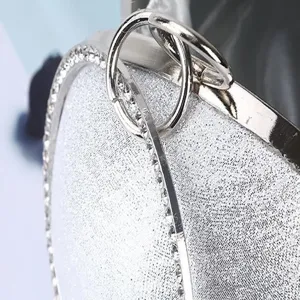 Sac de soirée sphérique à paillettes argentées avec strass et cadre métallique.