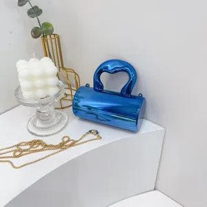 Glänzende blaue metallische zylindrische Abendtasche mit Kunstgriff und goldener Kette.