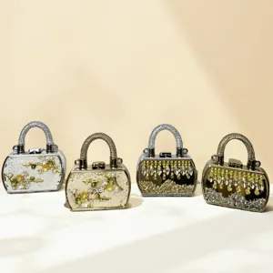 Elegante Mini-Abendtaschen mit Strassgriffen und metallischem Hartschalenrahmen.