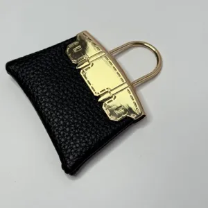 Mini sac à main noir en cuir PU avec détails de fermoir en métal doré de luxe.