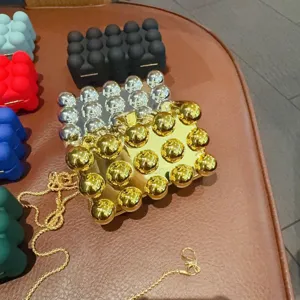 Dettagli in primo piano della lussuosa borsa da sera con borchie sferiche e catena.