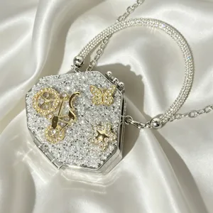 Detail view of sparkling crystal evening bag with cute bicycle butterfly and star charms.
