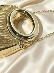 Goldene Glitzer-Abendtasche mit rundem Metallgriff und Kettriemen, elegantes Detailzubehör.