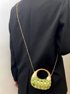 Detailansicht der Luxus Acryl Abendtasche mit funkelndem grünen Strass gewebtem Design.