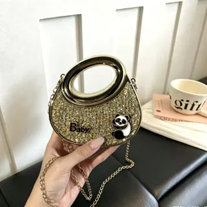 Detailansicht der goldenen glitzernden Acryl-Handtasche mit Metallring und Schulterkette.