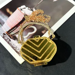Goldener Mini-Box-Taschen-Detail mit Glitzer-Chevron-Muster und Kristall-Griffkette.