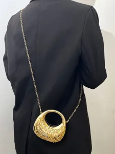 Detailaufnahme der eleganten goldenen Acryl Halbmond Umhängetasche mit feiner Kette.