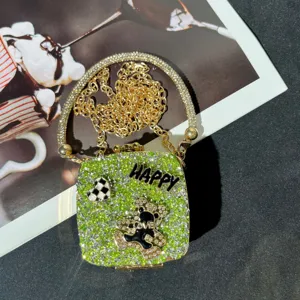 Nahaufnahme der Mini Strass Abendtasche mit funkelnden Kristallen, Kette und Bär.