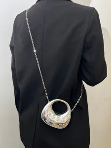 Detailansicht einer stylischen metallischen Crescent Umhängetasche mit Kette und Strass.