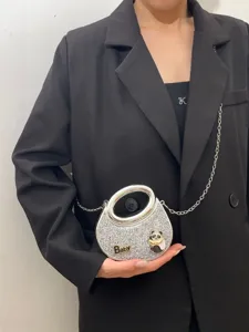 Detailansicht der silbernen Glitzer-Handtasche mit rundem Metallgriff und Panda-Anhänger.