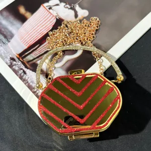 Detailansicht der goldenen Mini-Glitzer-Abendtasche mit Strassgriff und feiner Kette.