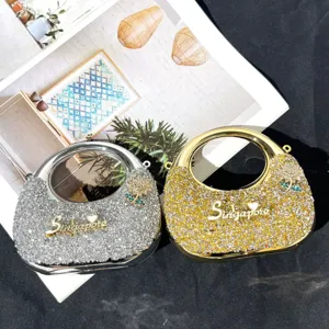 Glänzende Strass Abendtasche mit Metallring Griff und funkelnden Kristall Pailletten Details.
