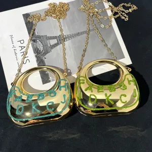 Detailansicht der goldenen Metallic-Crescent-Handtasche mit Kette und glänzenden Glitzer-Akzenten.