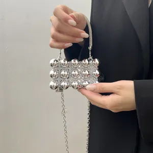 Silver beaded evening bag detail with rhinestone strap and metallic chain. Chic accessory.
