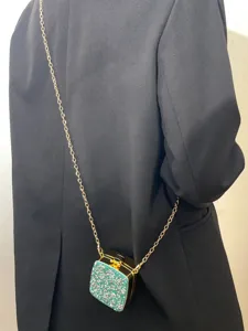 Detailaufnahme der Mini Acryl Abendtasche mit funkelnden Strasssteinen und goldener Kette.