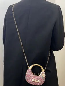 Elegante Strass-Umhängetasche mit Metallring-Griff und Kettengurt für Damen im Detail.