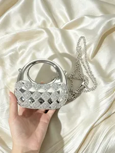 Elegantes Detail der silbernen Acryl-Abendtasche mit funkelnden Strasssteinen und einer Kette.