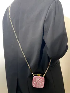 Detailansicht einer Mini Acryl Abendtasche mit Strass Steinen und goldener Kette.