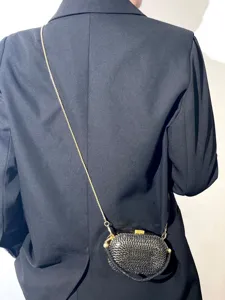 Detailansicht einer glitzernden Strass-Umhängetasche mit Metallkette, Mode-Accessoire.