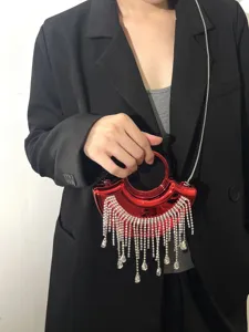 Detailaufnahme der roten metallischen Mini-Abendtasche mit funkelnden Kristallfransen und Kette.