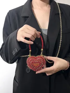 Detailansicht der Mini Herz Strass Abendtasche mit Goldkette und rotem Kristall Griff.