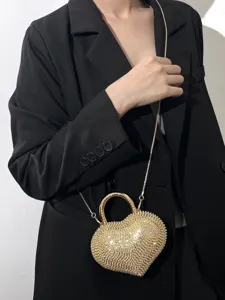 Primo piano dettagliato della mini borsa a tracolla da sera a cuore con strass dorati.