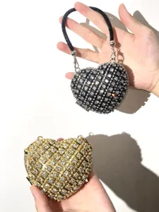 Glitzernde Strass-Herz-Clutch Detailaufnahme mit funkelnden Kristallen und Perlen-Tragegriff.